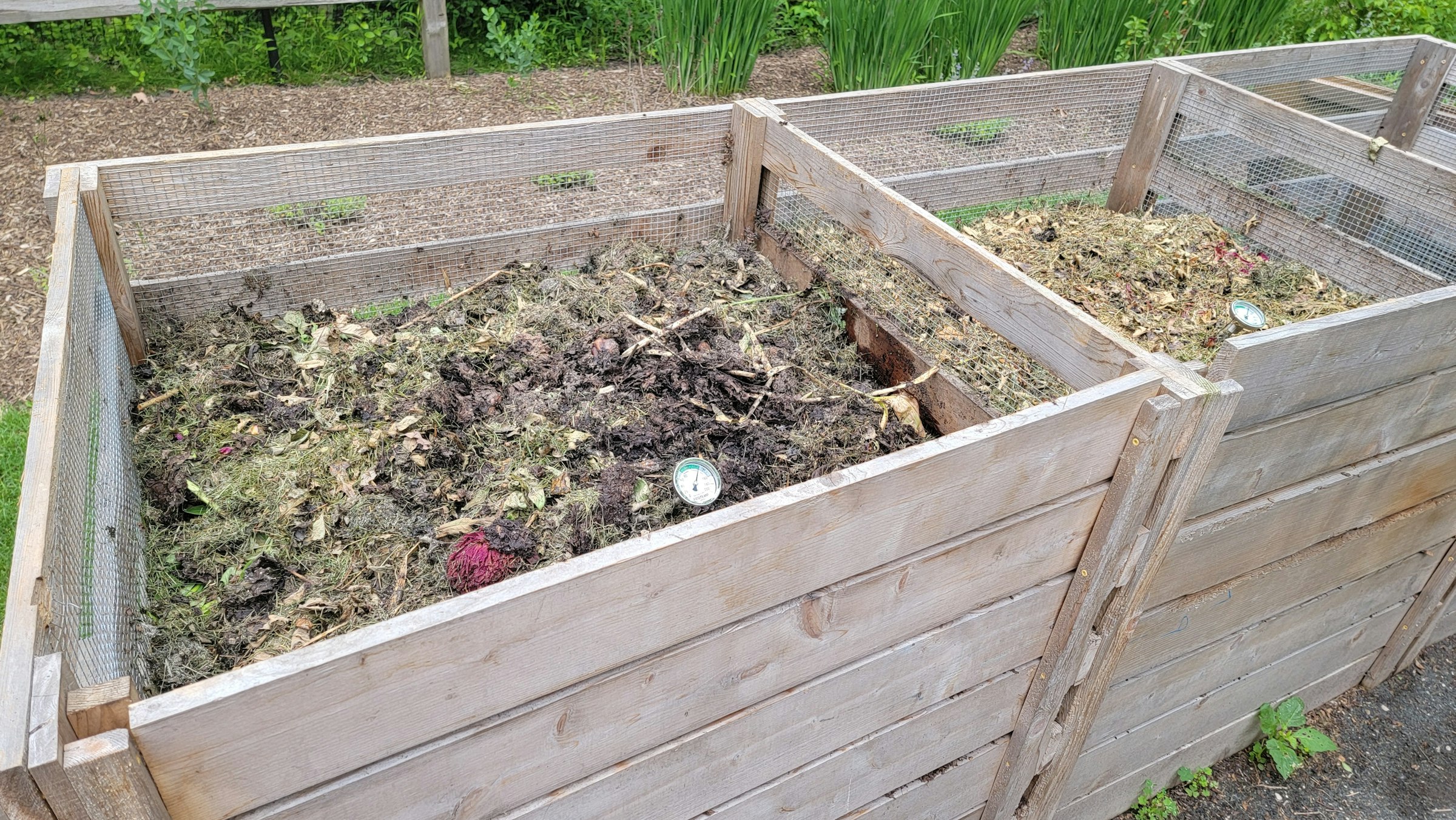 Open timber compost bays filled with garden scraps
