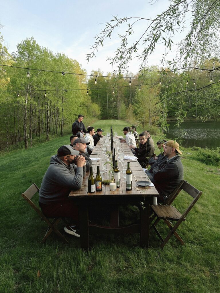 A long outdoor table set for a shared meal on the grass