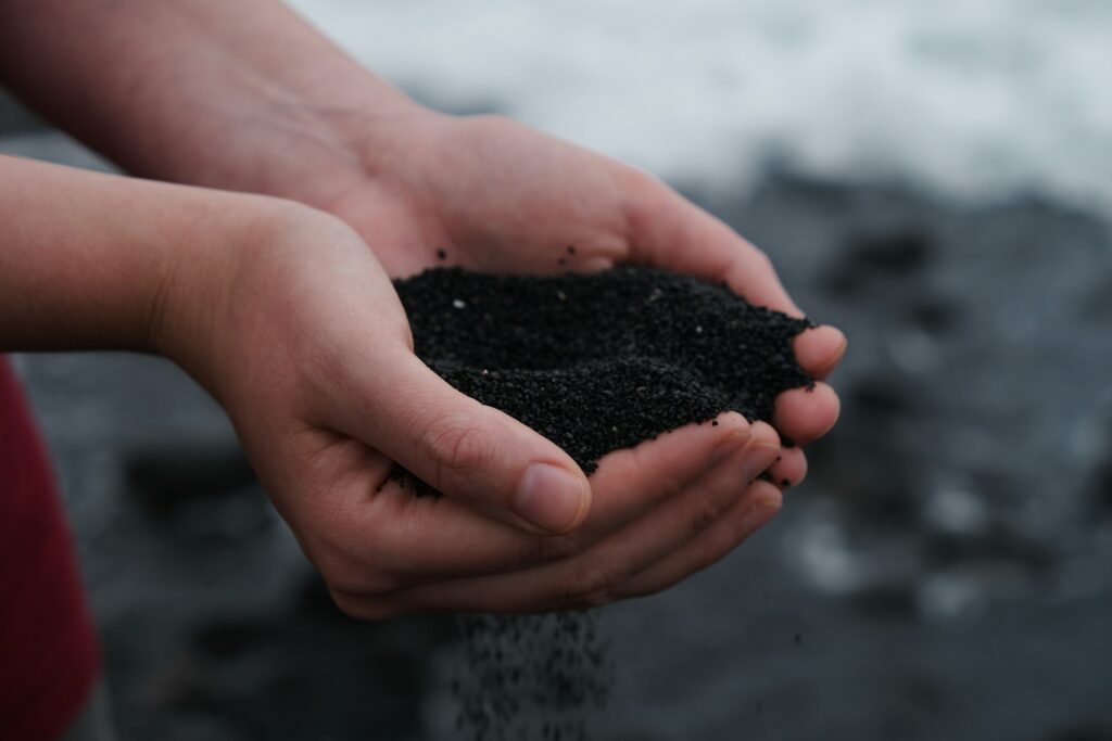 Two hands holding a mound of dark crumbly soil