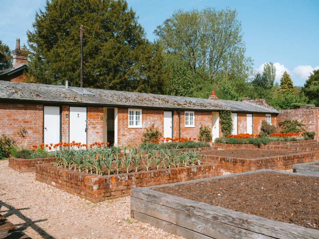 Rows of raised timber beds in front of a low brick building